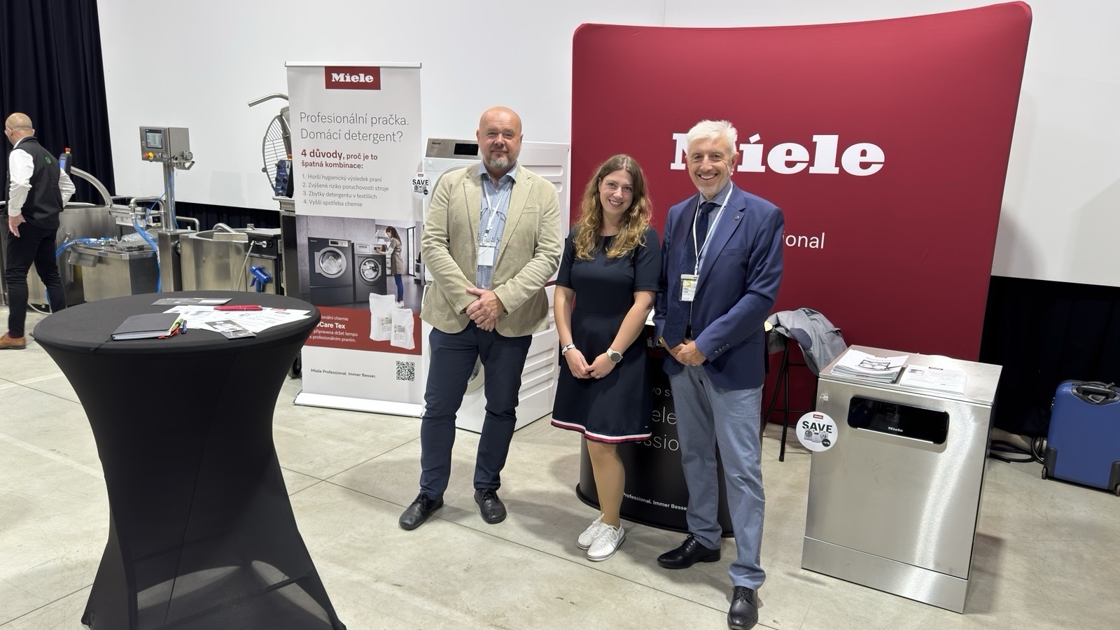 Pavel Ježek with Miele Professional representatives at a stand displaying professional technology
